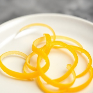 Citrus zest curl on pale background